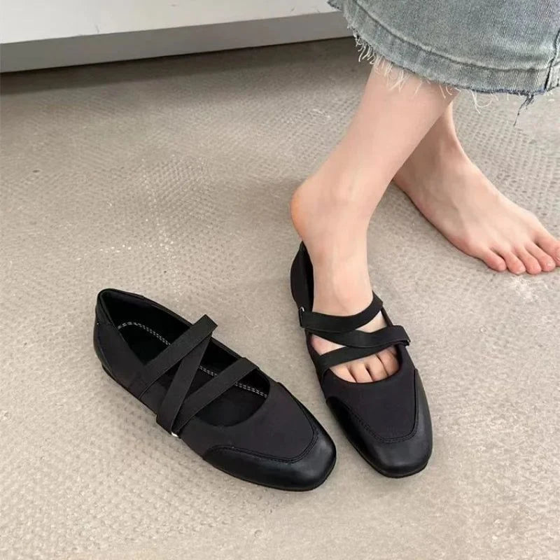 une ballerine portée et l’autre posée au sol près d’un pied