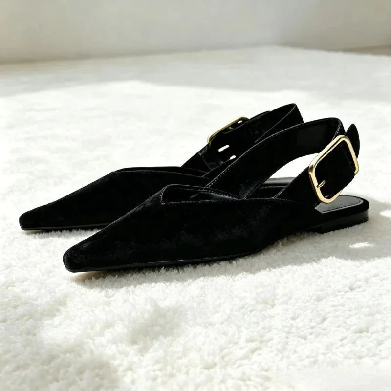 Paire de ballerines noires posée sur tapis blanc en lumière naturelle