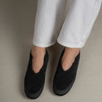 chaussons noirs portés, vue de face sur les pieds d’une femme