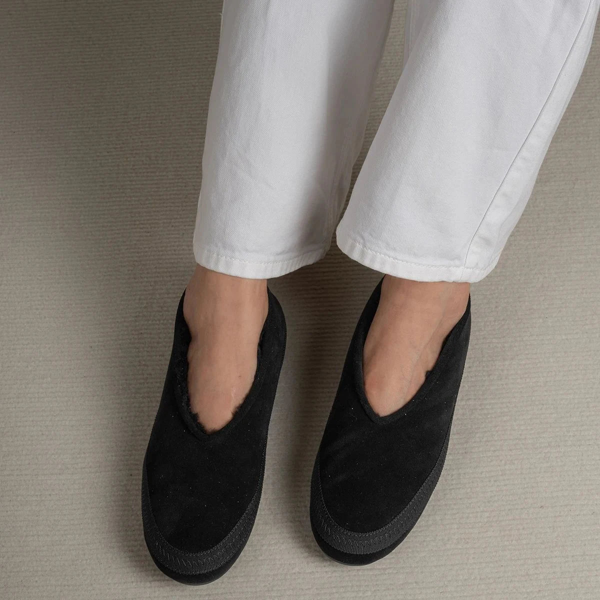 chaussons noirs portés, vue de face sur les pieds d’une femme