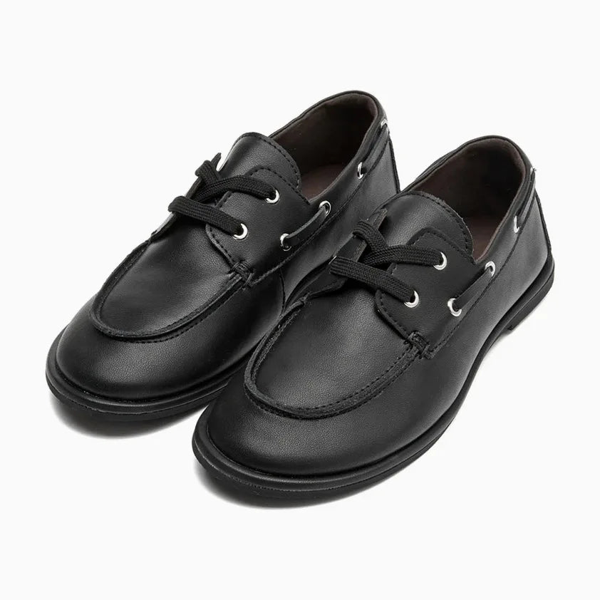 chaussure bateau femme cuir noire présentée de trois quarts sur fond blanc