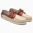 Paire de chaussures bateau beige et rouge avec lacets marron sur fond uni