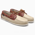 Paire de chaussures bateau marron et beige posée sur fond uni