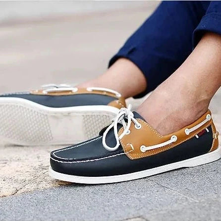 Chaussure bateau bicolore noire et beige portée en extérieur avec laçage blanc
