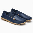 chaussures plates en cuir bleu marine posées sur fond uni