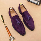 Deux mocassins violets posés avec embauchoirs sur surface beige