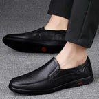 mocassins noirs portés vus de profil sur moquette grise