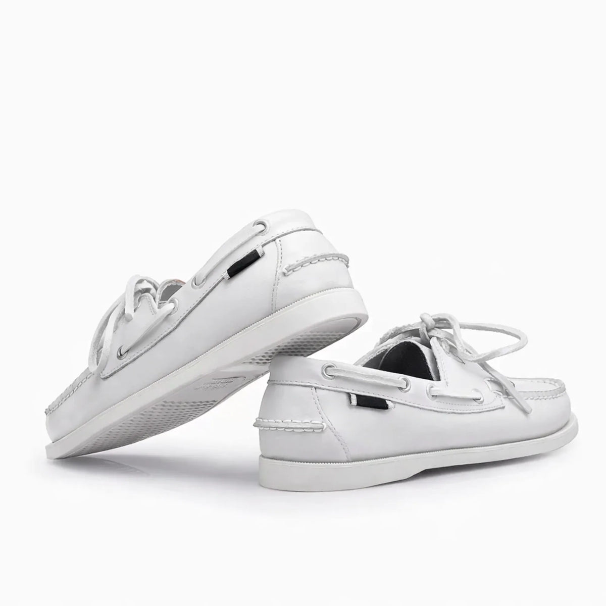 Paire de chaussures bateau en cuir blanc posée sur fond blanc