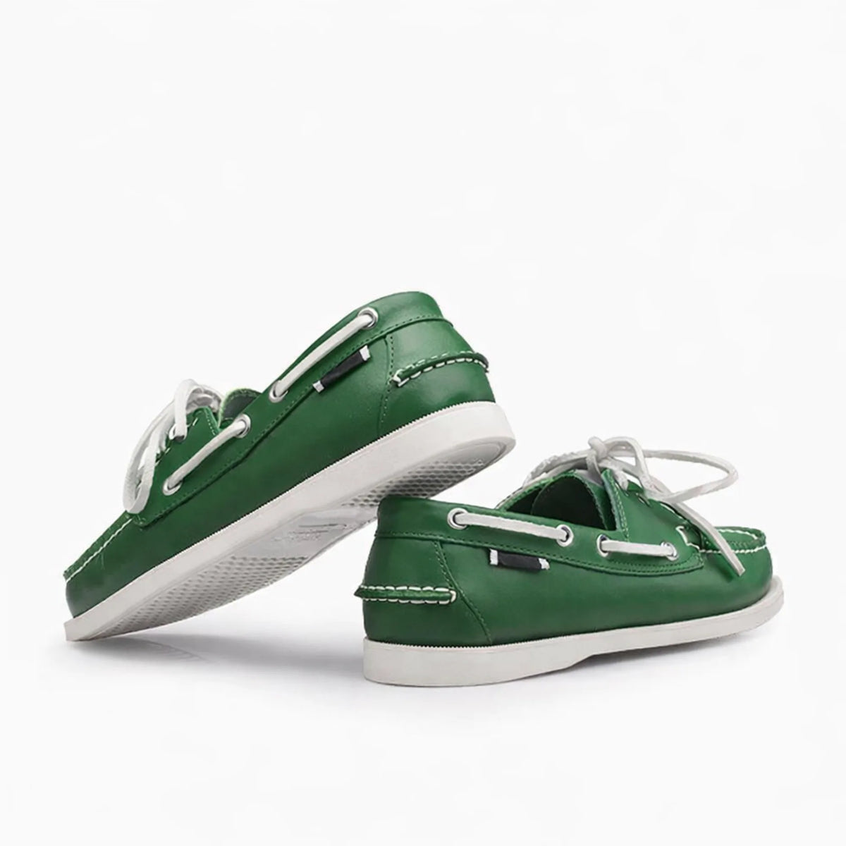 Paire de chaussures bateau verte en cuir posée sur fond blanc