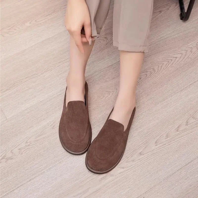 vue du dessus des mocassins marron portés, jambes repliées sur le sol