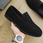 Mocassin à bride homme coloris noir velours, paire tenue à la main