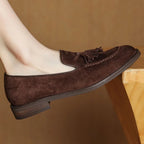 Mocassin marron porté, posé sur le bord d’un meuble en bois clair