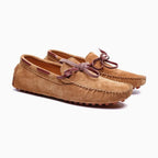 paire de mocassins à lacet coloris marron posée sur fond uni