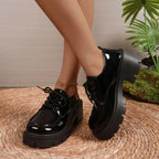 paire de chaussures noires portée avec pantalon et accessoires dorés