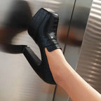 un mocassin noir à talon porté, gros plan sur la chaussure avec arrière-plan métallique