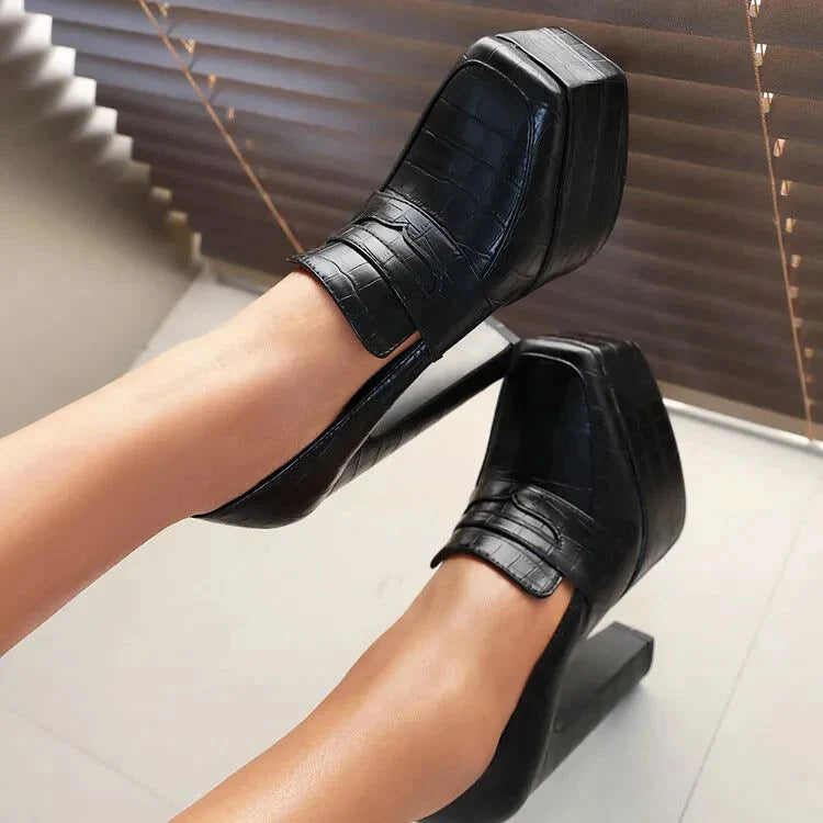 paire de mocassins noirs à talon haut portée, vue du dessus, jambes allongées