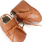paire de bottillons marron vue du dessus, détail sur la languette ourson