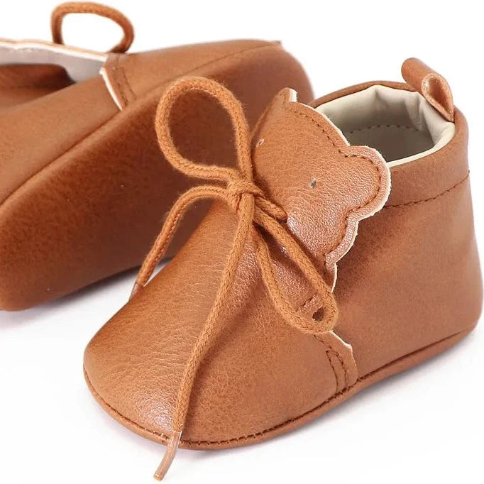 vue latérale de bottines marron pour bébé avec lacets et oreilles décoratives