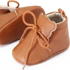 vue latérale de bottines marron pour bébé avec lacets et oreilles décoratives