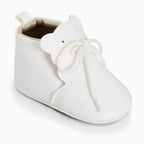 petite bottine bébé blanche avec détails de surpiqûres et nœud sur le dessus