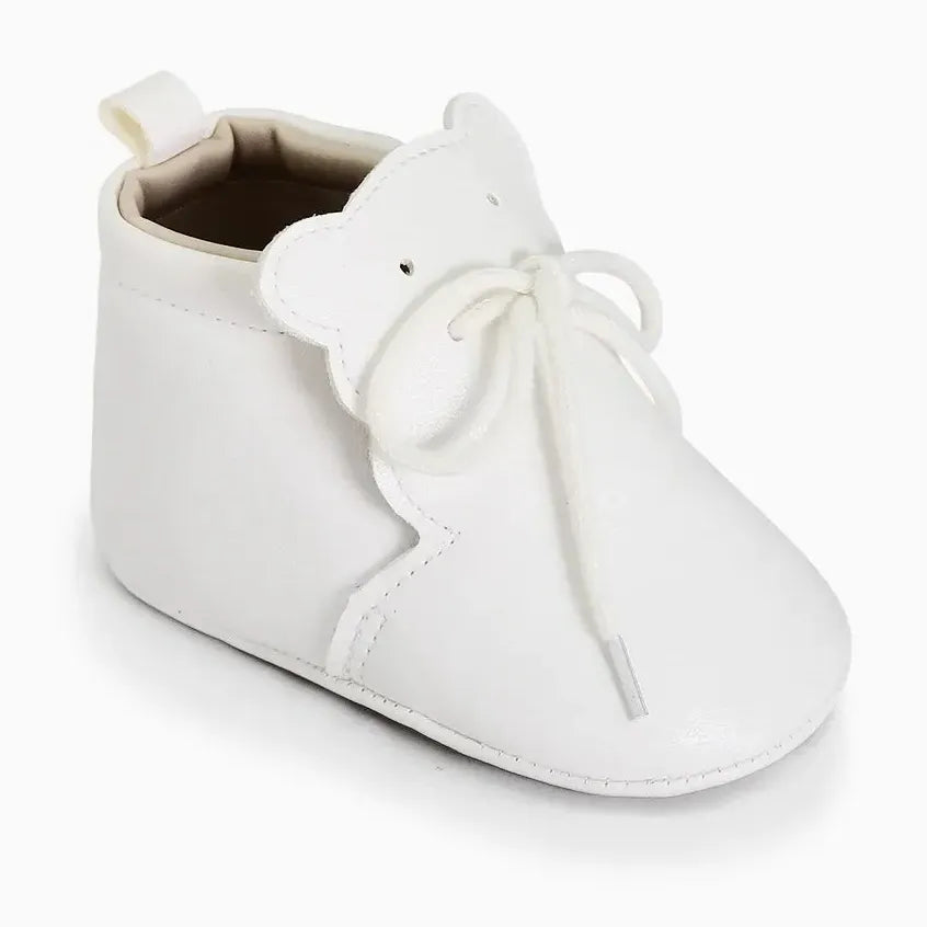petite bottine bébé blanche avec détails de surpiqûres et nœud sur le dessus