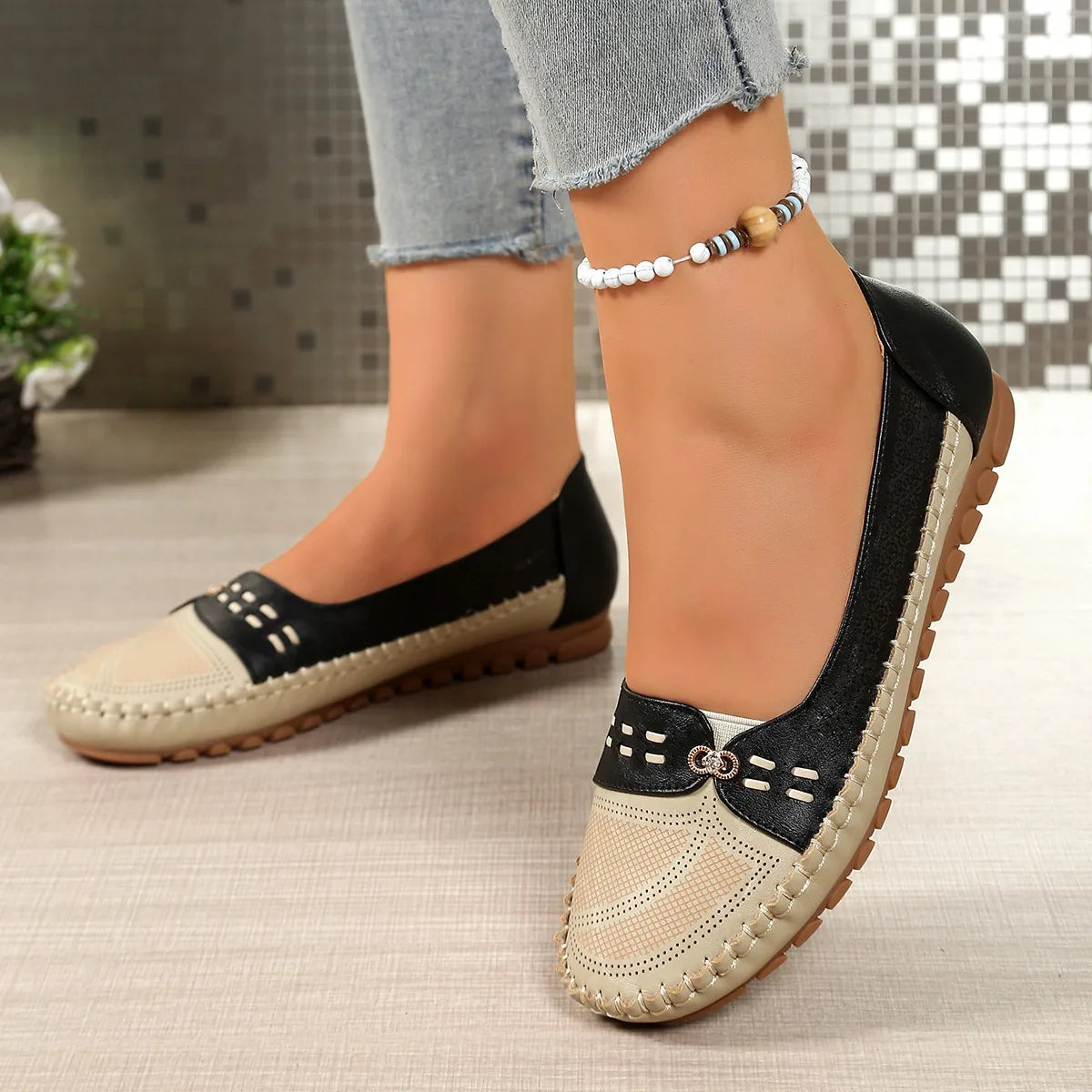 mocassins bicolores beige et noir portés avec un jean