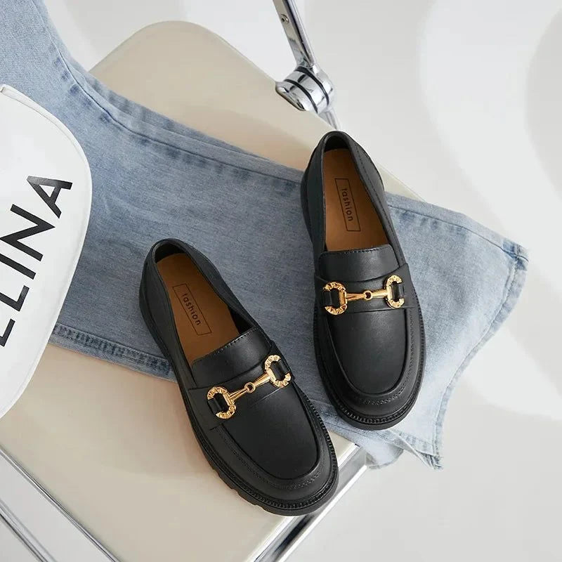 La paire de mocassins noirs vue du dessus posée sur une chaise claire