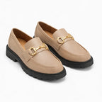 Le mocassin à boucle présenté en coloris beige avec semelle noire