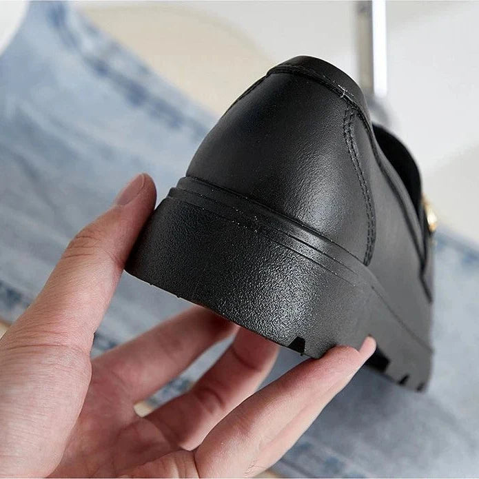 Détail du talon et de la semelle du mocassin noir tenu à la main