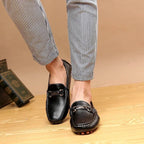 mocassins noirs portés avec un pantalon à rayures verticales