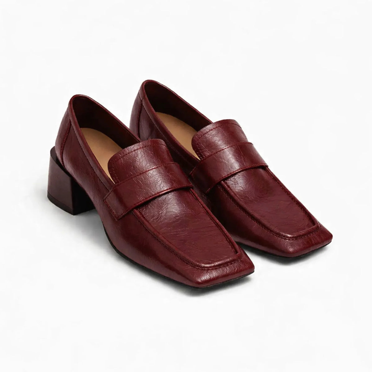 Mocassins à talon carré en coloris bordeaux posés sur fond uni