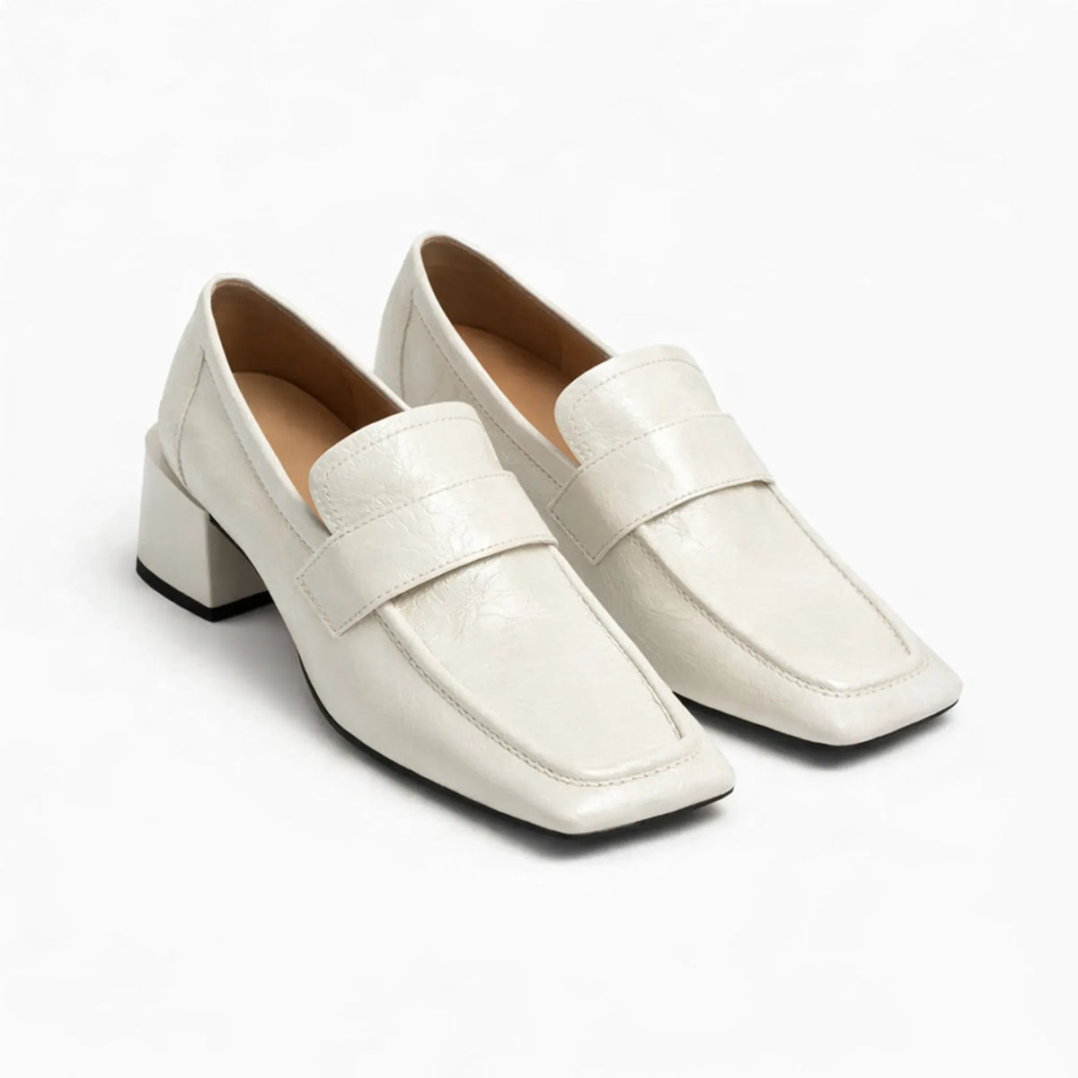 Paire de mocassins à talon épais en coloris crème sur fond blanc