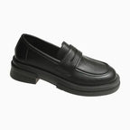 mocassin chunky femme noir posé sur fond clair avec semelle épaisse apparente
