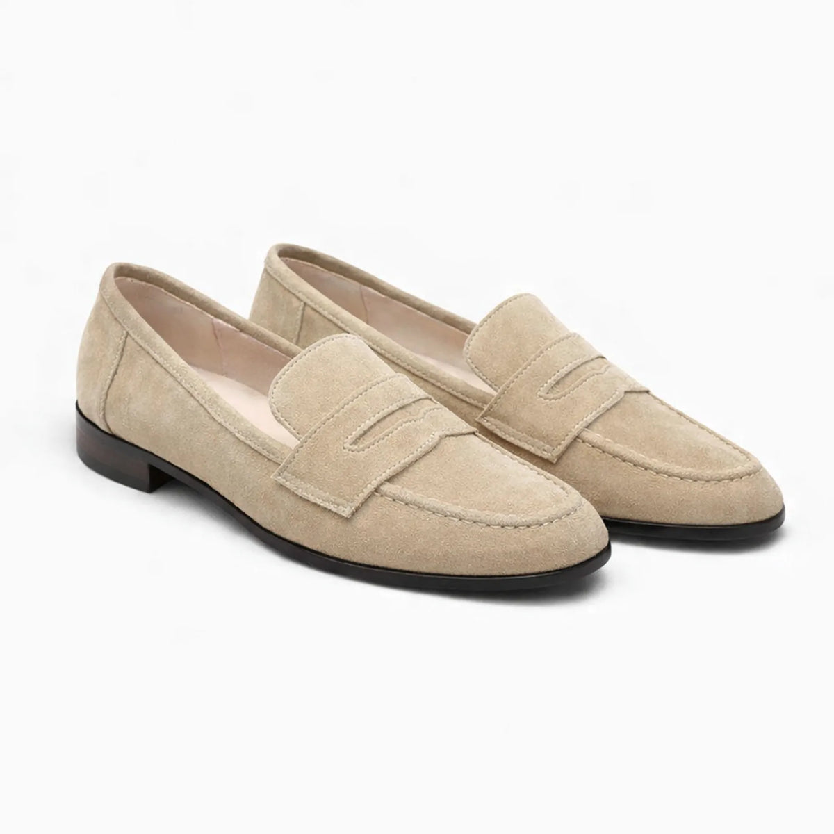 paire de mocassins en daim beige sur fond blanc
