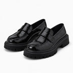 mocassin croco femme en vernis noir à semelle épaisse sur fond uni blanc