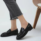 vue latérale des mocassins noirs portés avec un pantalon coupé frangé