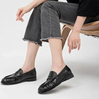 les mocassins noirs portés avec un pantalon gris assis sur une chaise