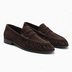 mocassin daim marron femme posé sur fond uni clair, vue de trois quarts avant