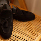 gros plan sur le dessus d’un mocassin en daim foncé avec détail des pampilles