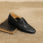 Mocassin noir posé sur un livre fermé, ambiance chaleureuse