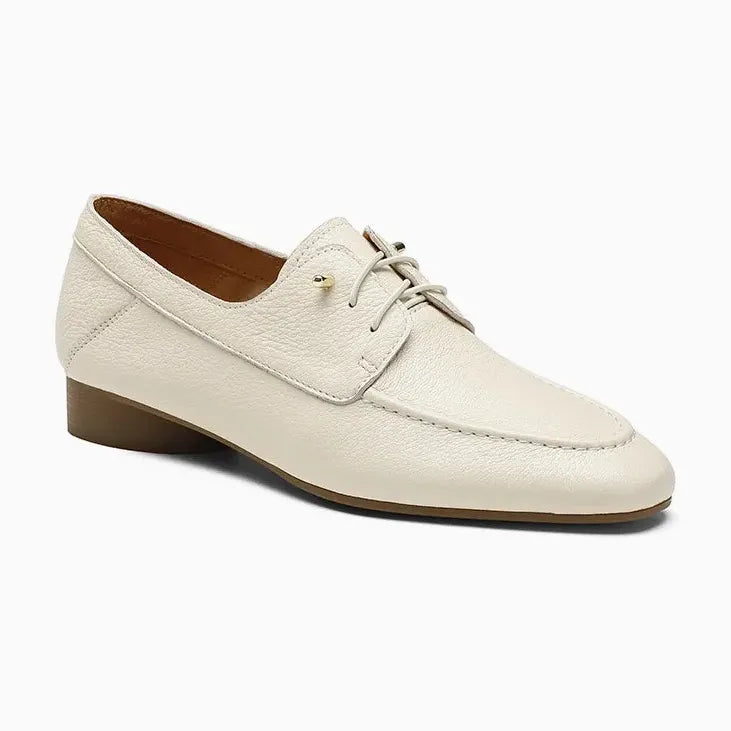 Mocassin en cuir beige à petit talon présenté sur fond uni