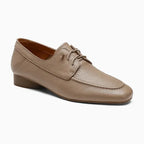 Mocassin en cuir taupe à petit talon présenté sur fond uni