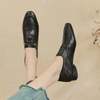 Mocassins noirs portés pieds relevés, vue du dessus et de trois quarts