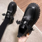 Vue en plongée sur les chaussures portées, détails gothiques bien visibles