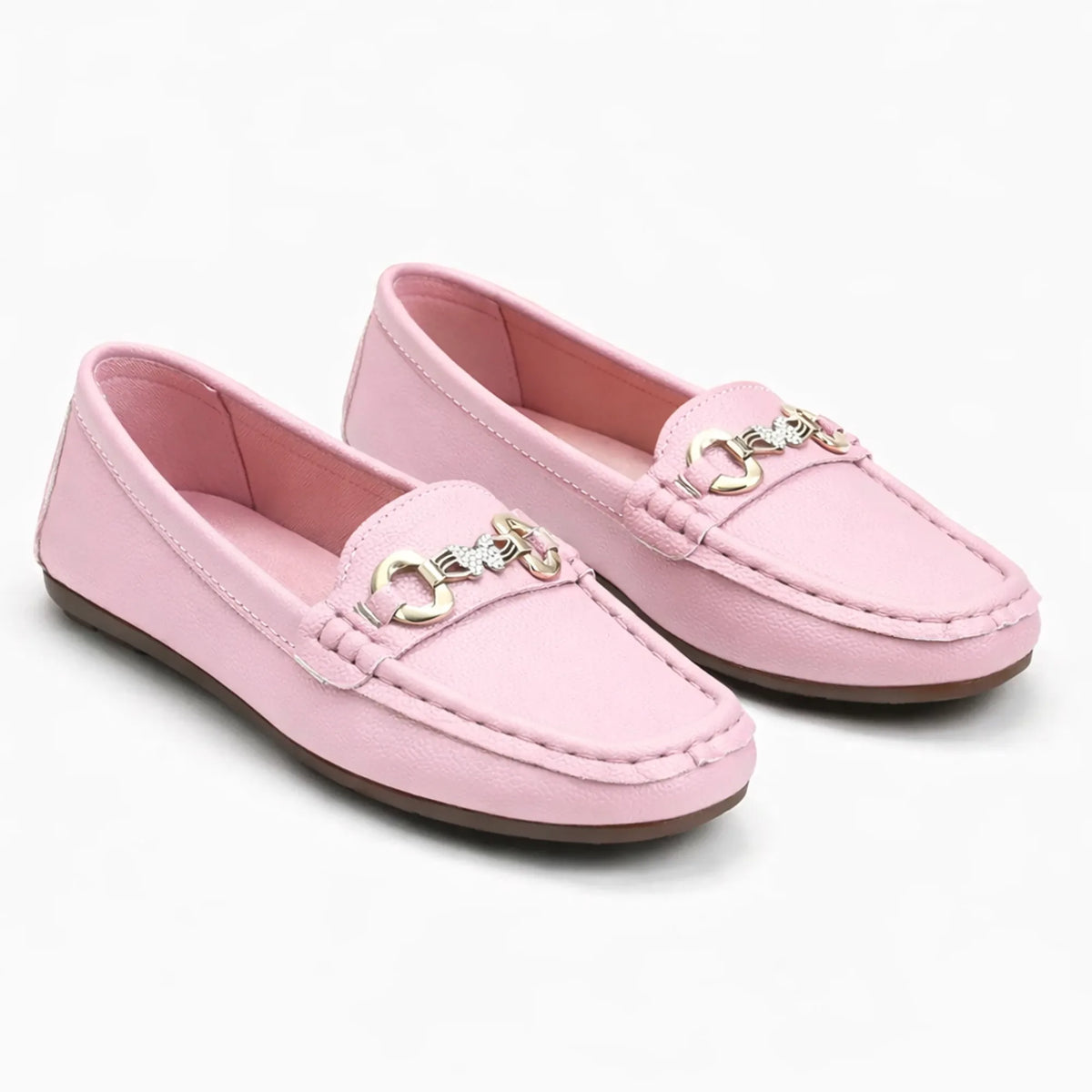 mocassins roses avec ornement métallique doré disposés sur fond clair