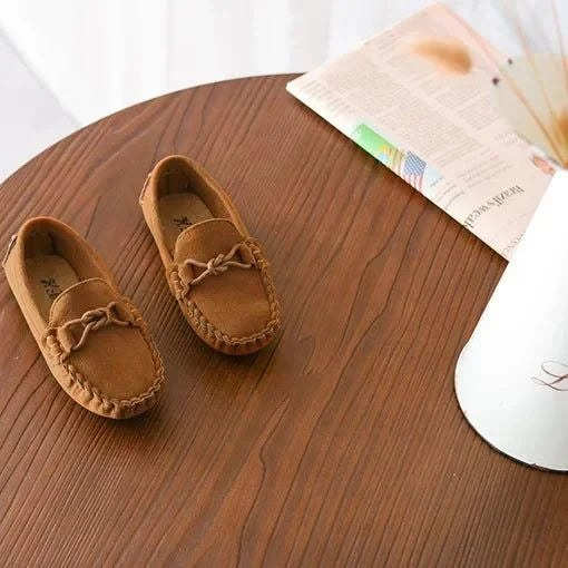 paire de mocassins marron vue de dessus sur une table en bois