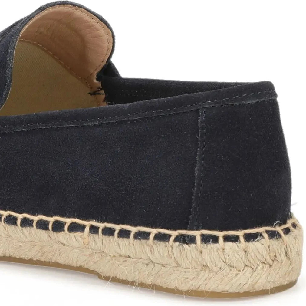 gros plan sur le talon d’un mocassin en daim noir avec détail couture jute