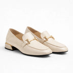 Mocassins élégants coloris beige à talon bas et ornement doré sur fond blanc