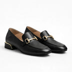 Mocassin femme chic noir à talon bas avec détail doré sur fond uni clair