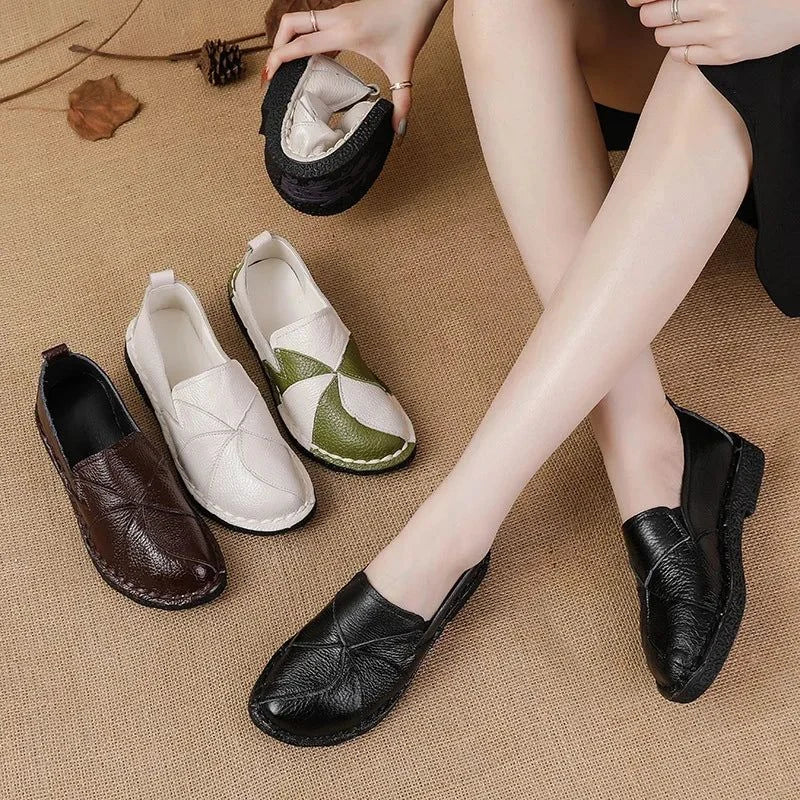 Trois paires de mocassins posées au sol, une paire noire portée